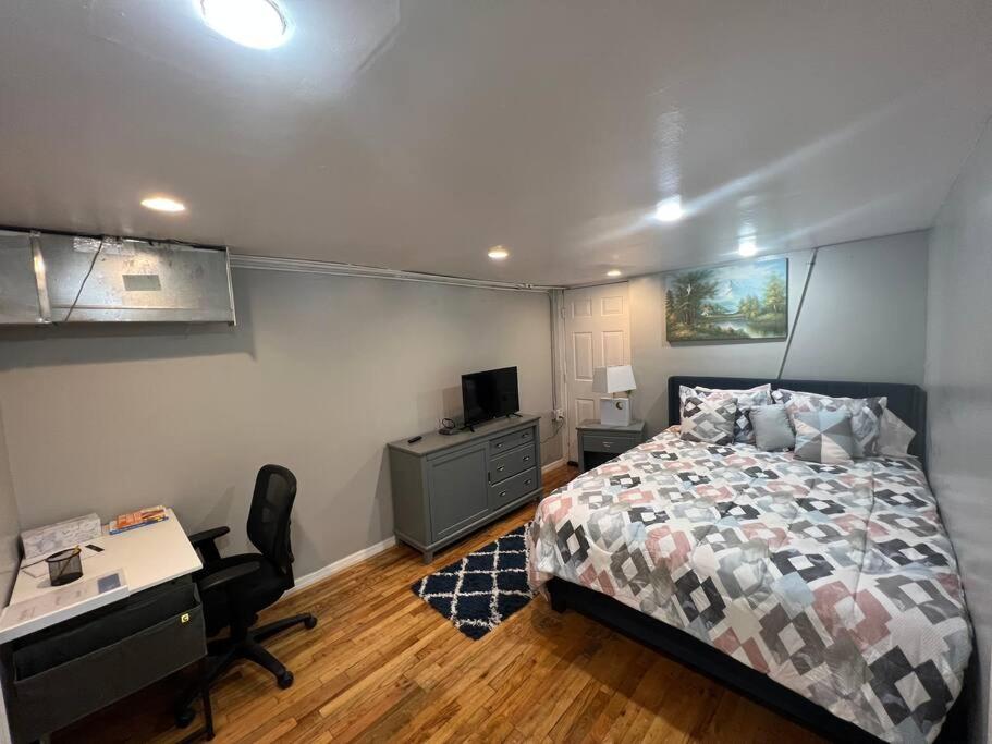 a bedroom with a bed and a desk and a computer at The Legato Suite in Brooklyn