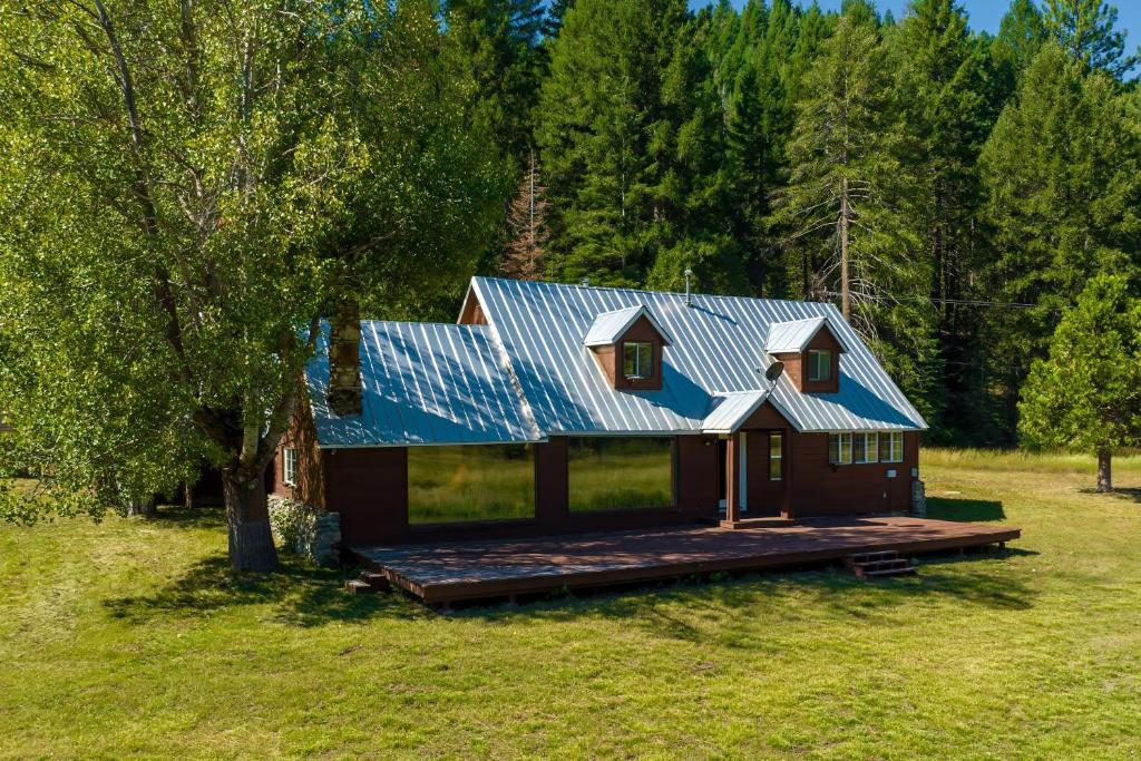 uma casa com um telhado azul e um deque em Meadow House | The Lost Sierra Ranch em Graeagle