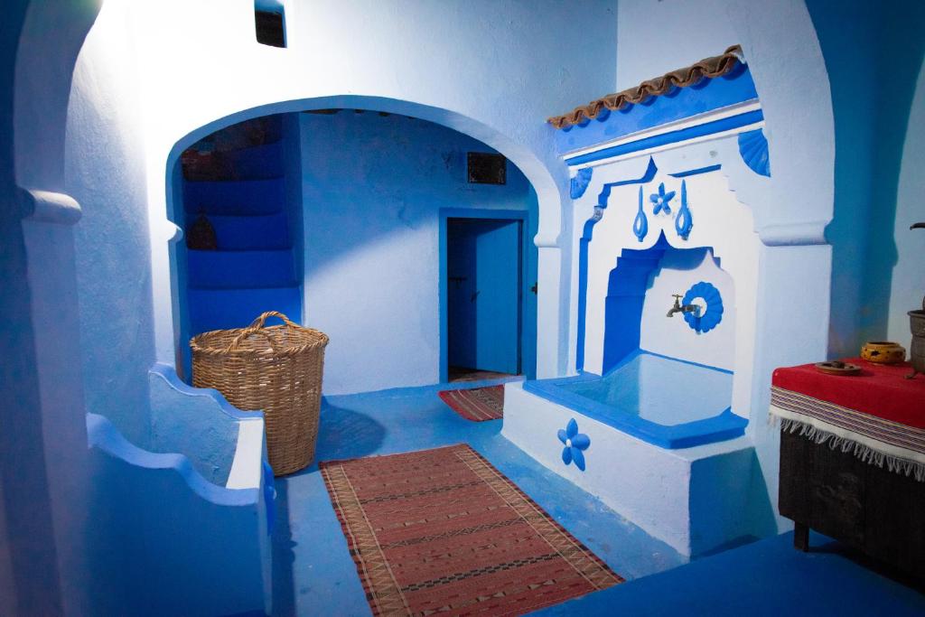 ein blau-weißes Zimmer mit einem Korb auf dem Boden in der Unterkunft Dar Dadicilef in Chefchaouen