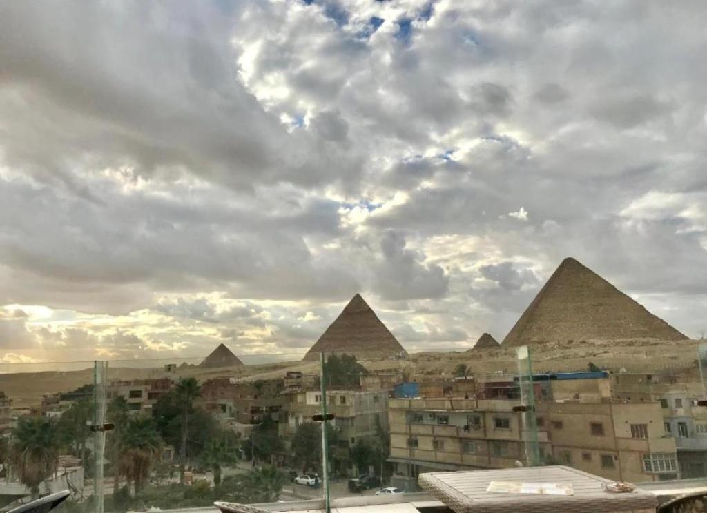 a view of pyramids in a city under a cloudy sky at black pyramids view in Cairo