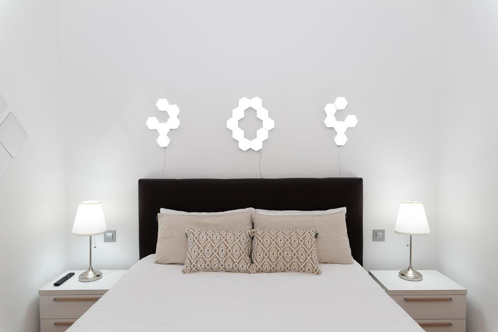 a bedroom with a white bed with two lamps at AndBnB I Refugio sobre el Río, Esquí y Parking gratis in Ransol