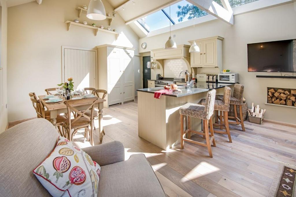 een keuken en een woonkamer met een tafel en stoelen bij Williamston Cowshed in Slaggyford