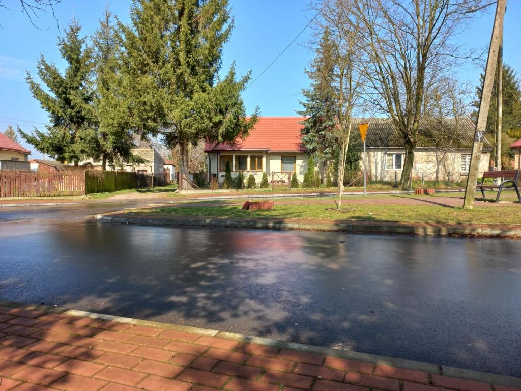 a street with a pond in front of a house at Apartament Senator Stężyca in Stężyca