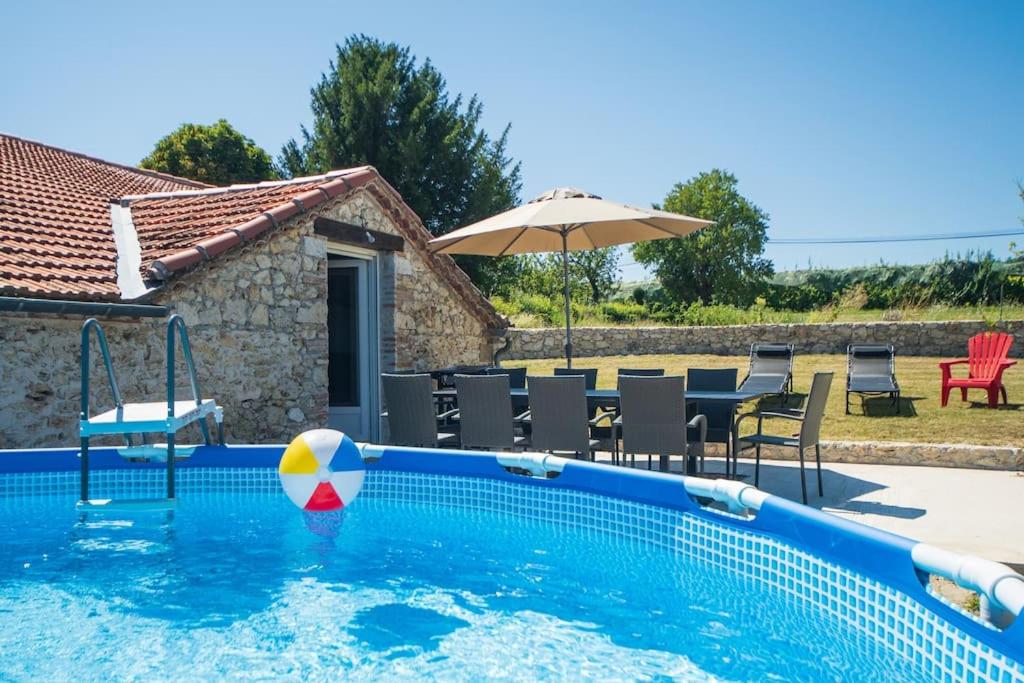 una piscina con una pelota de playa en el agua en Villa pierre campagne en Brassac