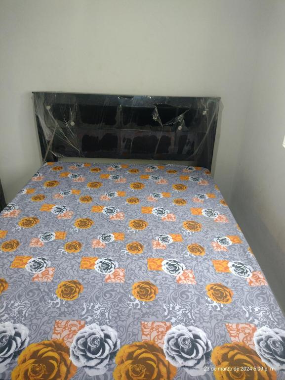 ein Bett mit einer Bettdecke und Blumen darauf in der Unterkunft Hostal Altamar De La Guajira in Ríohacha