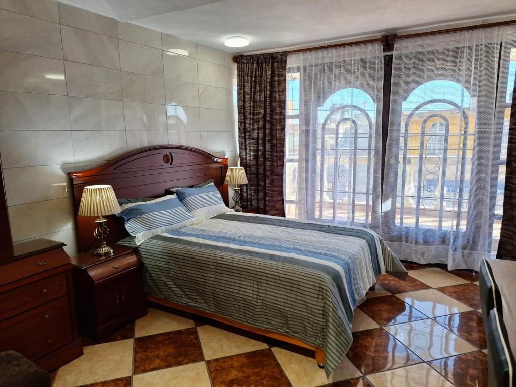 ein Schlafzimmer mit einem Bett und einem großen Fenster in der Unterkunft Bonita casa chica con amplio patio in Coatepec