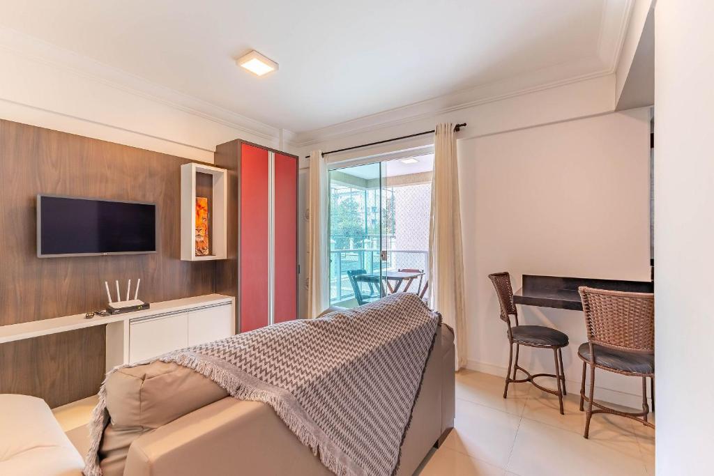 - une chambre avec un lit, un bureau et une table dans l'établissement Apartamento em Bombas - Ótimo para Famílias, à Bombinhas