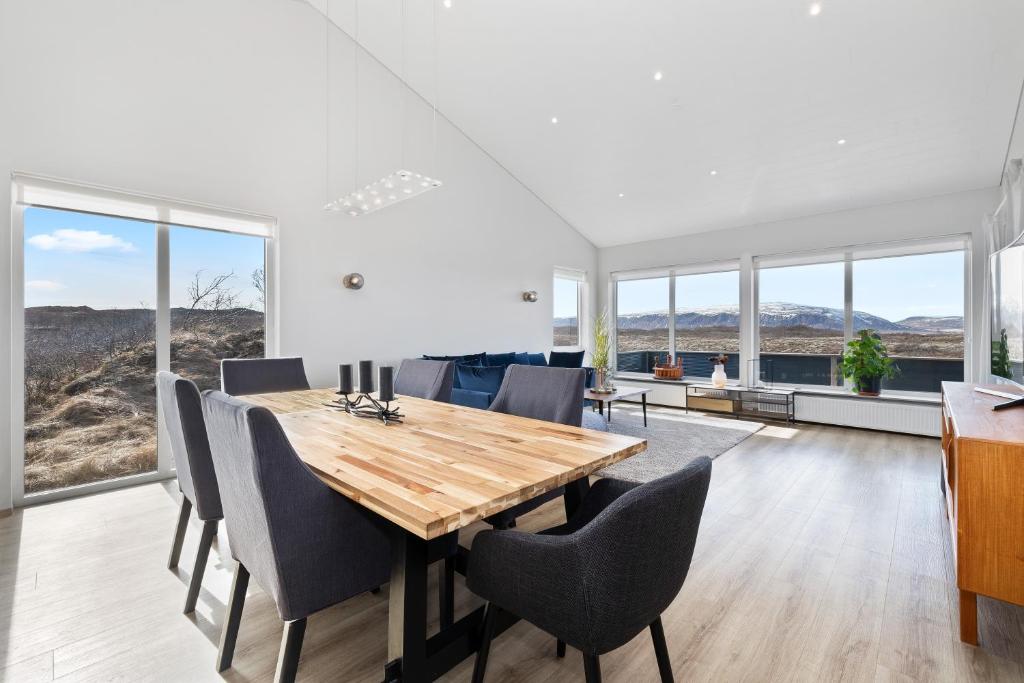 a dining room with a wooden table and chairs at Luxury Villa in Golden Circle with hot tub in Selfoss