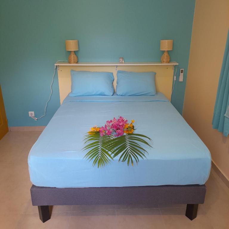 un letto con un mazzo di fiori sopra di canelle a Le Diamant