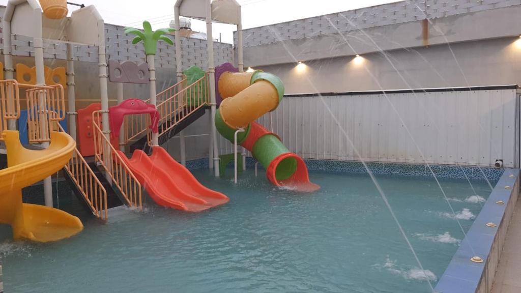 une piscine d'eau avec toboggan dans l'établissement شاليهات طيف البحر العاب مائية للأطفال, à Ad Darb