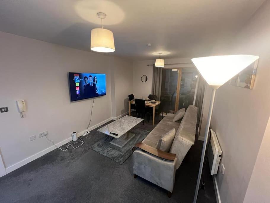 a living room with a couch and a tv on the wall at AO Arena flat Manchester, with parking in Manchester