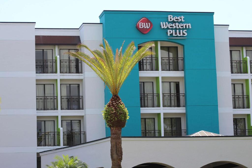 a palm tree in front of the best western plus hotel at Best Western Plus Deerfield Beach Hotel & Suites in Deerfield Beach