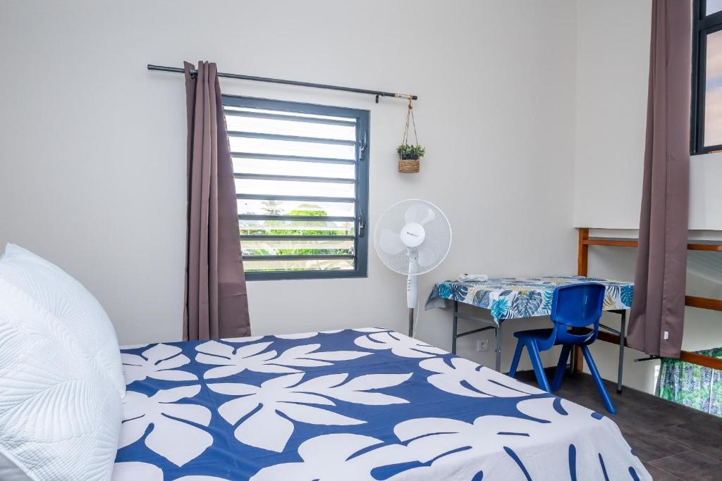 a bedroom with a bed and a desk and a window at Cosy Studio Anahoa 1 in Papeete in Papeete