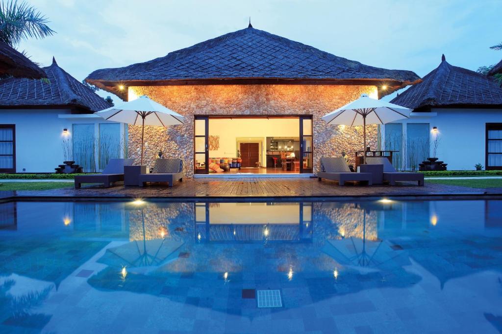 a villa with a swimming pool at night at Villa The Jiwa in Tanjung