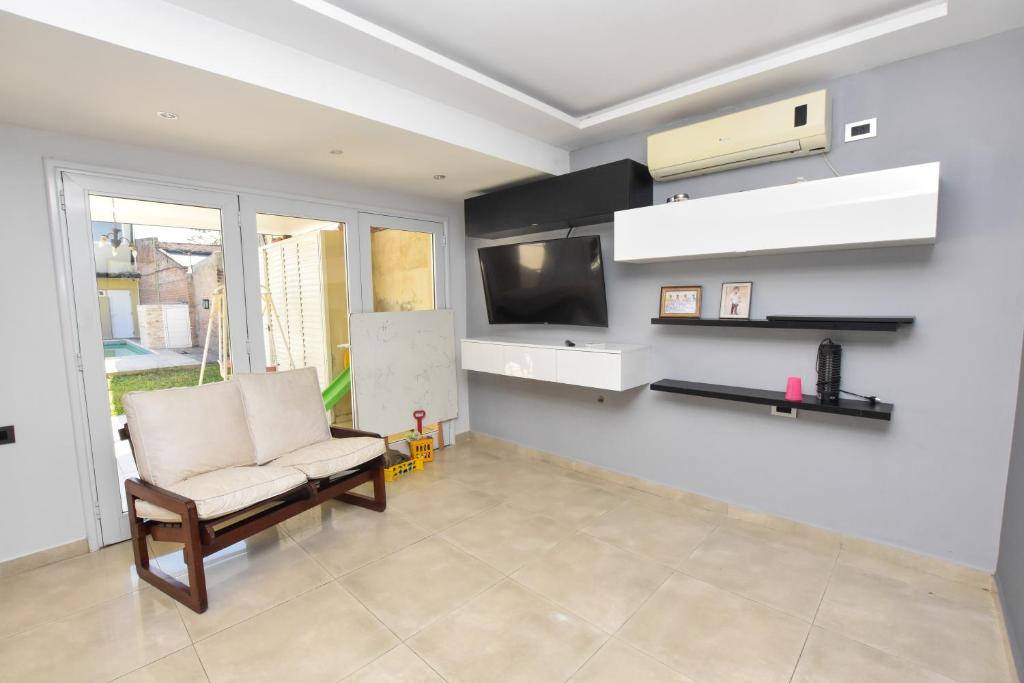 Una sala de estar con una silla y un televisor. en Casa relax, en Presidencia Roque Sáenz Peña