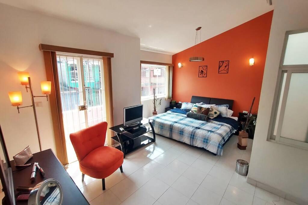 Schlafzimmer mit einem Bett, einem Schreibtisch und einem Stuhl in der Unterkunft King Size, jacuzzi, Dream House: oasis of peace in Coatepec