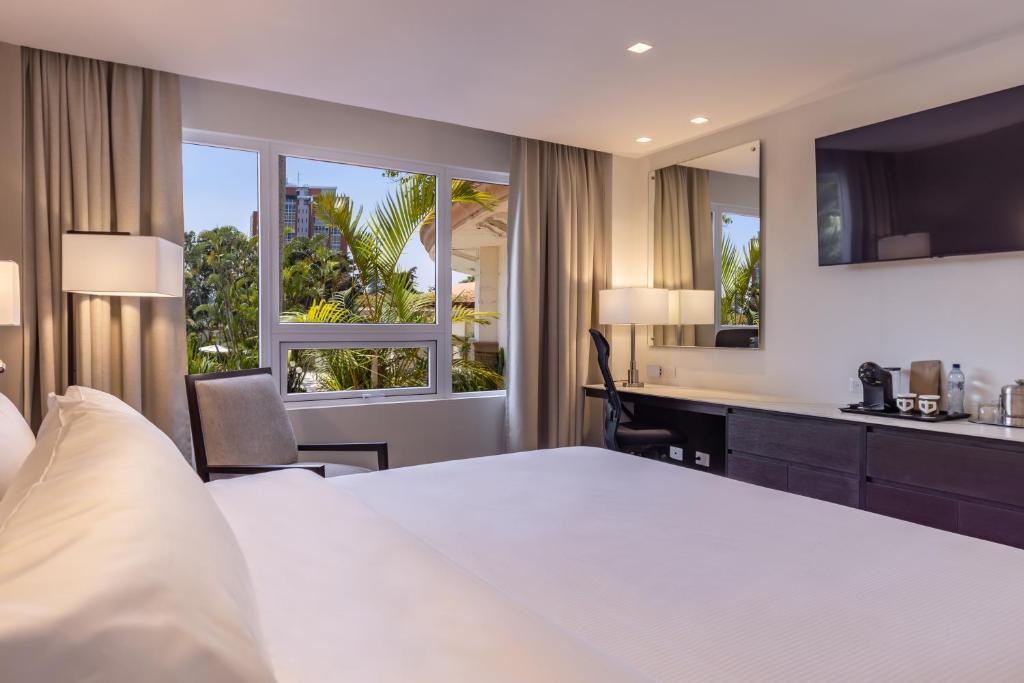 a hotel room with a bed and a desk and window at Hotel Biltmore in Guatemala