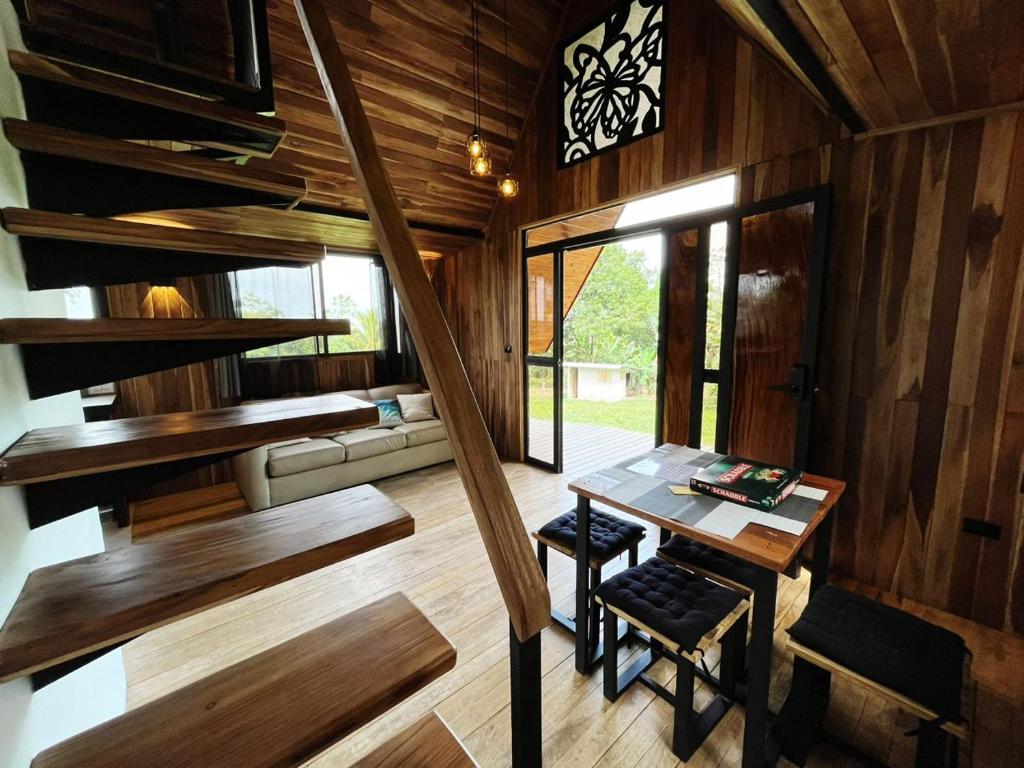 a room with a table and a staircase in a house at Myra Chalets in Bijagua