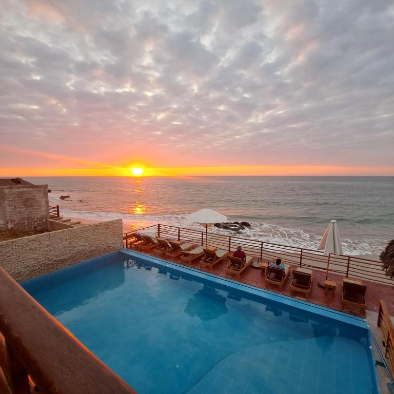 a swimming pool with a view of the ocean at Akas Hotel Apartamentos in Canoas de Punta Sal
