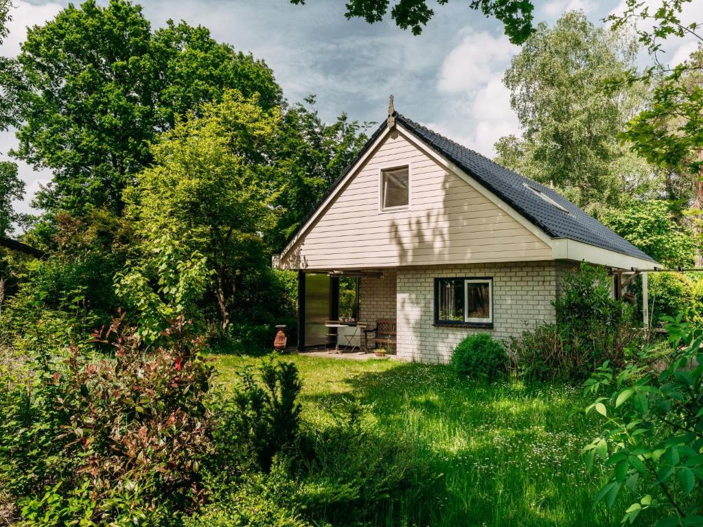 una pequeña casa blanca en medio de un patio en Noordikhoeve, en Reutum