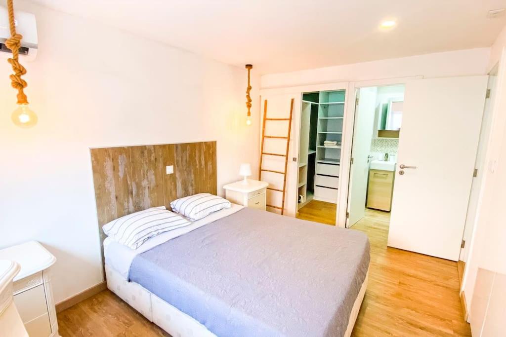 een slaapkamer met een wit bed in een kamer bij HU2i - In&Out Carcavelos in Carcavelos