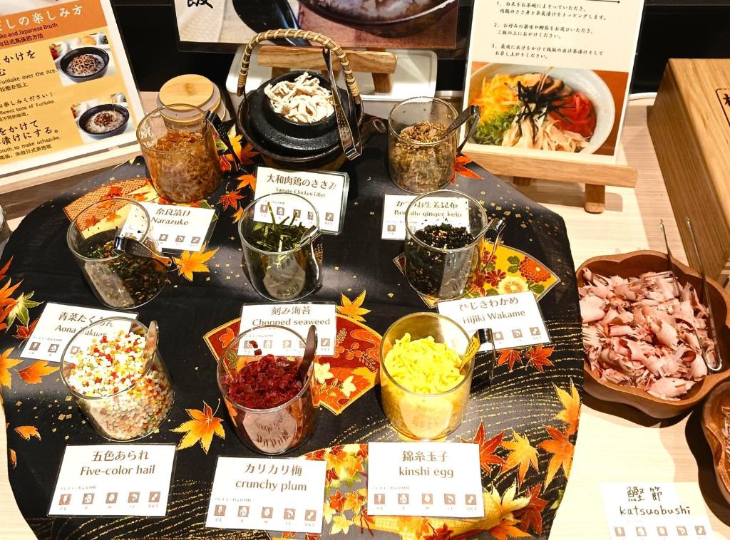 a table filled with different types of food with signs at Iroha Grand Hotel Kintetsu Nara Ekimae in Nara