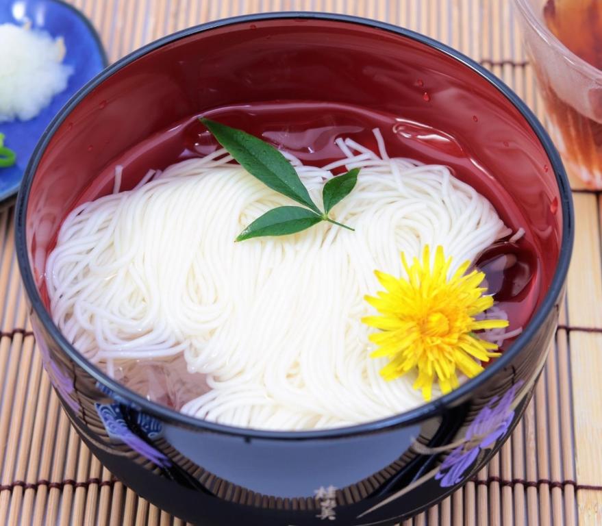 a bowl of noodles with a yellow flower on top at Iroha Grand Hotel Kintetsu Nara Ekimae in Nara