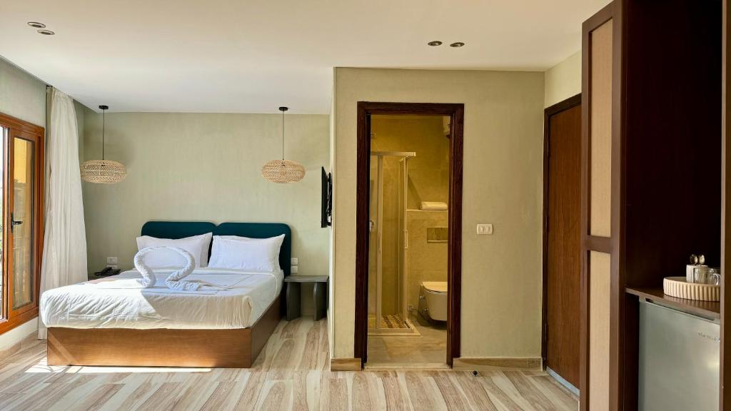 a bedroom with a bed and a bathroom at Almas Pyramids Hotel in Cairo