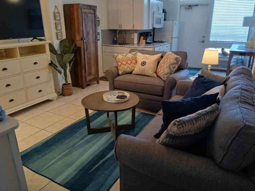 een woonkamer met 2 banken en een salontafel bij Direct ocean front view 1 bedroom working pool in Daytona Beach