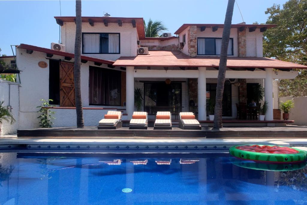 una casa con piscina frente a una casa en La Casa Bonita en Puerto Escondido