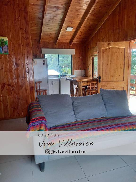 een groot bed in een kamer met een keuken bij Cabaña 1 Vive Villarrica in Villarrica