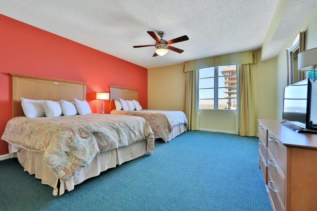 a hotel room with two beds and a flat screen tv at Ocean Walk Condominiums in Daytona Beach