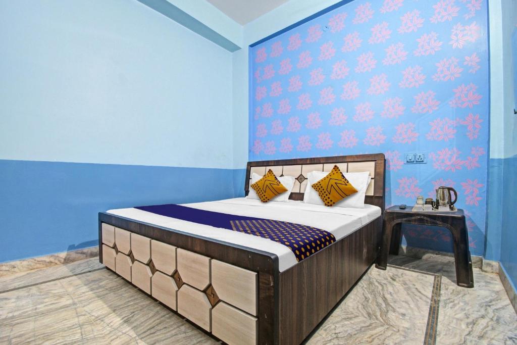 SPOT ON Hotel Rj14 في جايبور: غرفة نوم بسرير وجدار ازرق