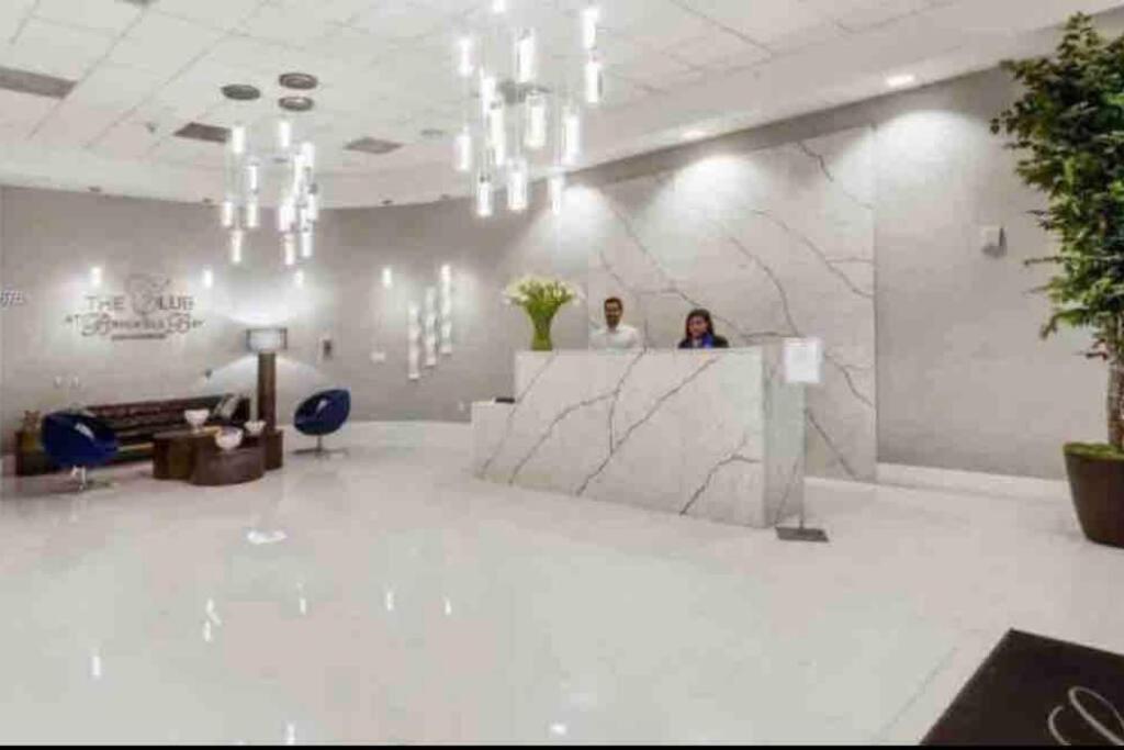 two people standing at a counter in a lobby at Stunning 1 BDR 1 BTH • Brickell • Bay & City Views in Miami