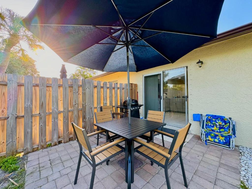 a table and chairs with an umbrella on a patio at Seaside Elegance 3 Mi to FM Beach Paradise Sleep 6 in Fort Myers Beach