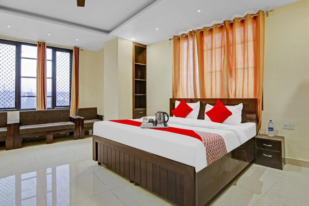 a bedroom with a large bed with red pillows at Flagship Hotel Starwood in Jammu