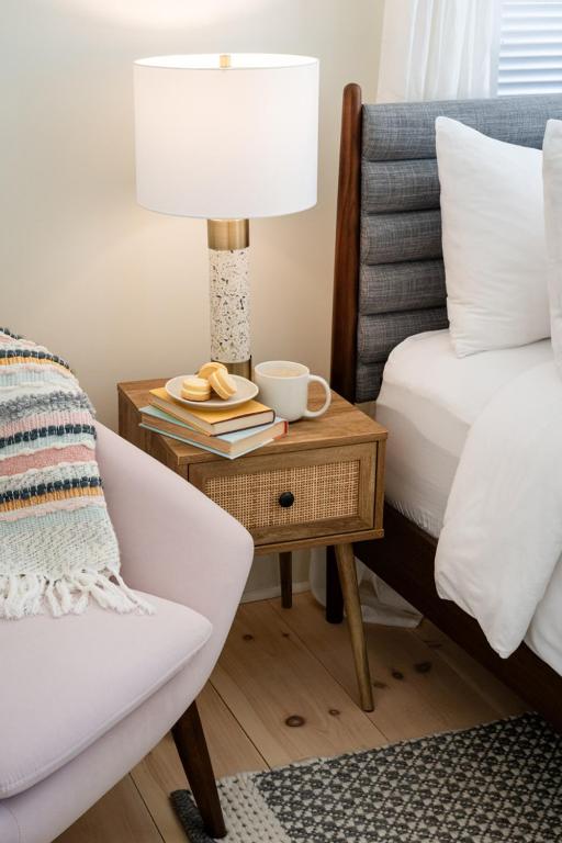 a bedroom with a bed and a table with a lamp and a chair at The August House in Windsor