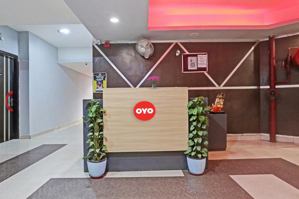 um lobby com uma cabine de aoops com dois vasos de plantas em OYO Flagship Red Stay Near V3S Mall em Nova Deli