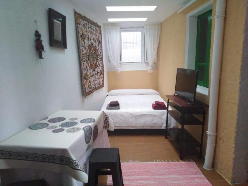 een kamer met 2 bedden en een televisie. bij 3 bedroom house near beach lighthouse hiking trail in Corme-Puerto