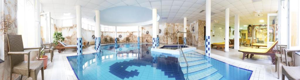 a large swimming pool in a large room with at Aphrodite Hotel in Zalakaros