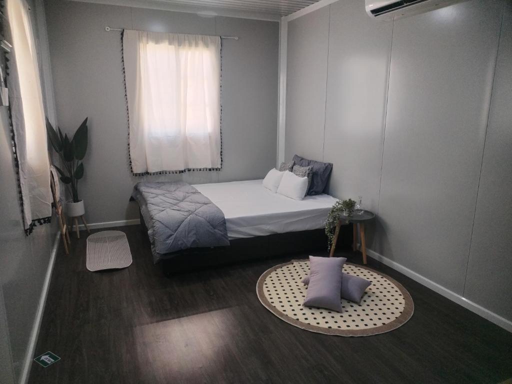 a small bedroom with a bed and a window at The Vanilla Cabin in Kampong Tanjong Gelam