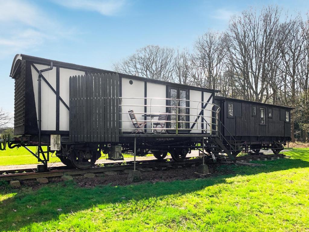 un vagón de tren blanco y negro en las vías en The Brake Wagon en Halstead