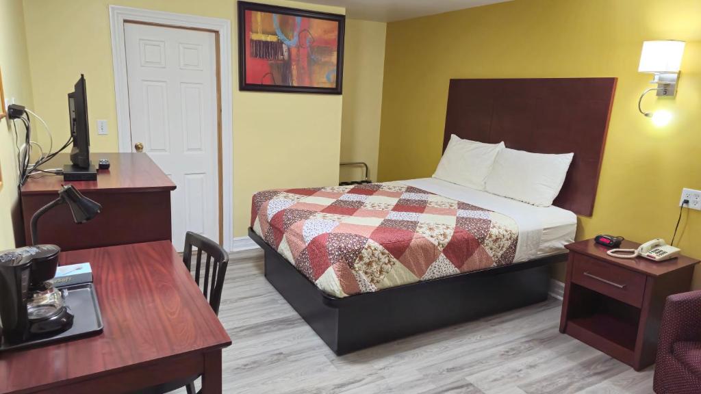 um pequeno quarto de hotel com uma cama e uma secretária em Deep River Motel em Deep River