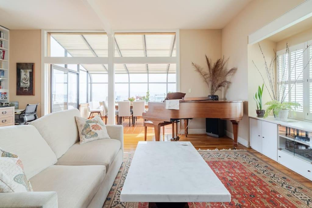 舊金山的住宿－Dreamy 3-Story House : Sunroom + City Skyline View，带沙发和钢琴的客厅