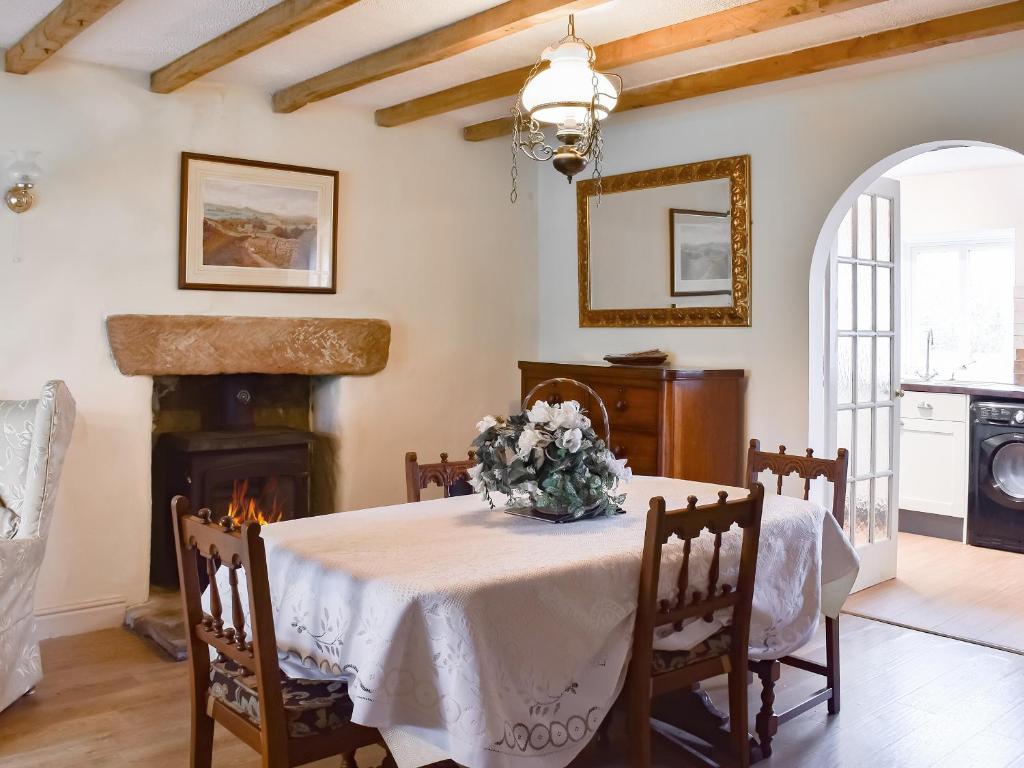 a dining room with a table and a fireplace at Mitsys Cottage in Darley