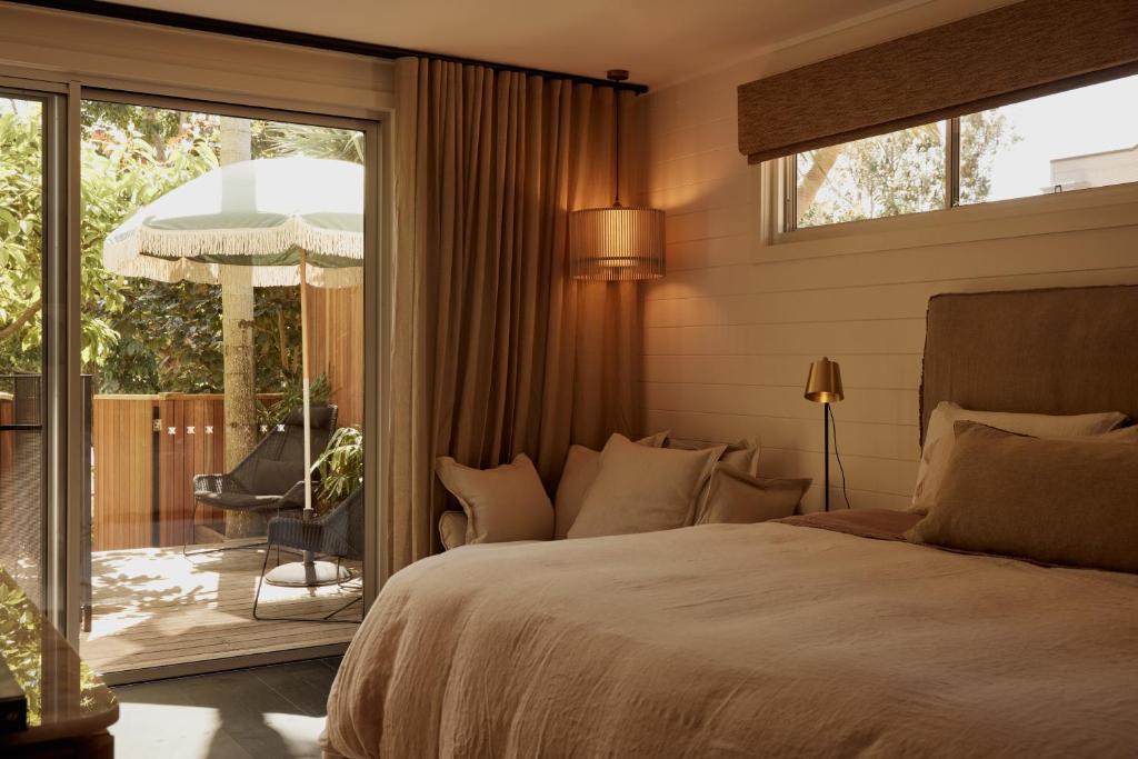 a bedroom with a bed and a sliding glass door at 28 Degrees Byron Bay - Adults Only in Byron Bay