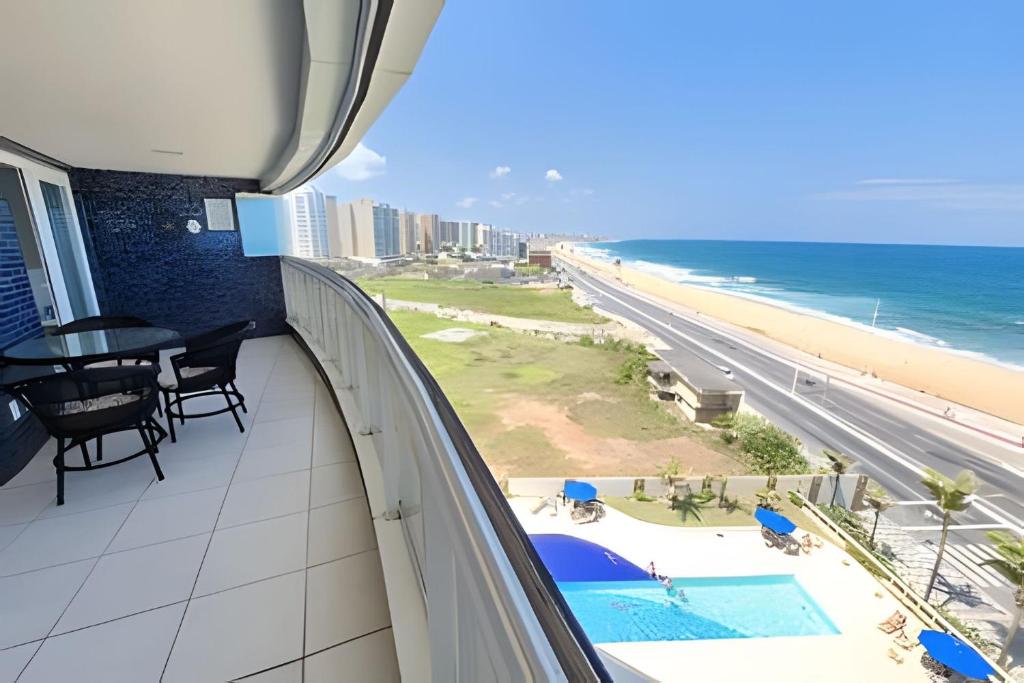 einen Balkon mit Blick auf den Strand und das Meer in der Unterkunft Vista Mar Apartamento em Armação in Salvador