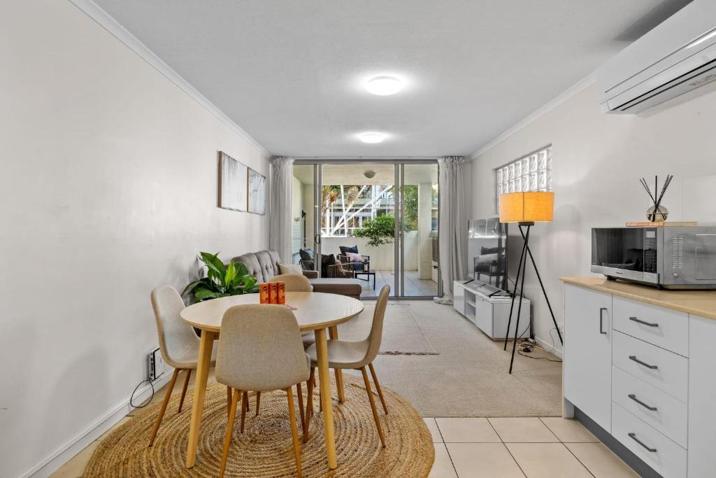 a kitchen and dining room with a table and chairs at South Vale Apartments South Brisbane in Brisbane