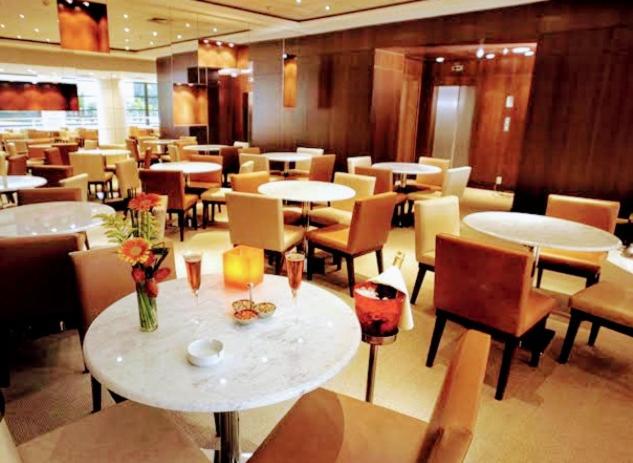 a restaurant with tables and chairs with flowers on them at Hotel M-RCURE - Av Paulista - GRAND PLAZA - Deluxe king Studio Veranda - BATH SPA - Executive Class - By LuXXoR in Sao Paulo