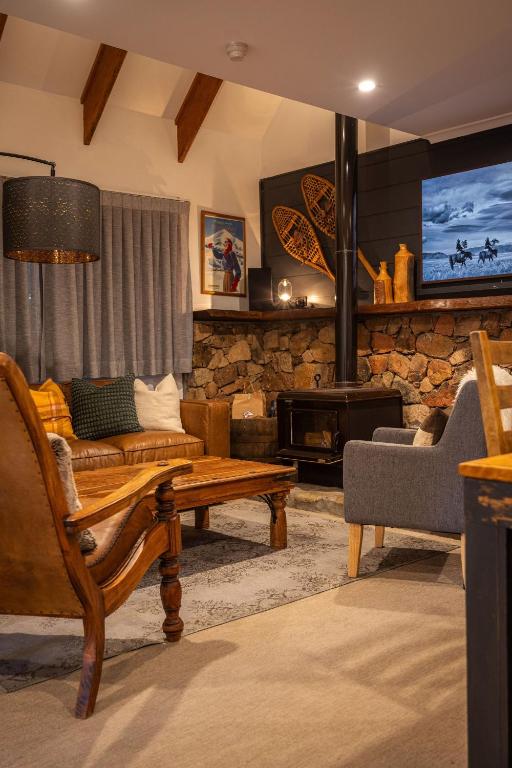 a living room with a couch and a fireplace at Crackenback Castle free standing chalet with fire place in Thredbo